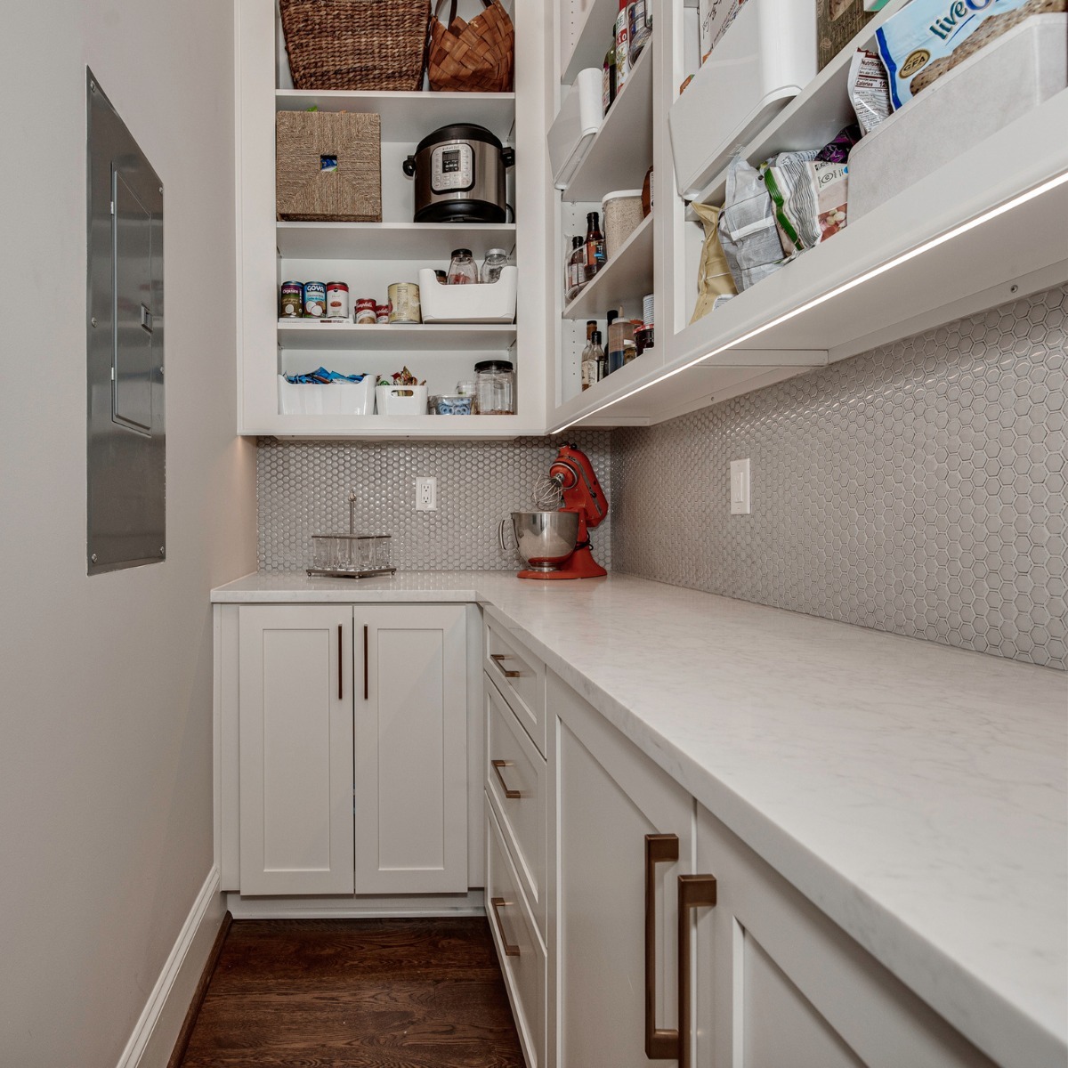 Custom pantry remodel with built-in shelving, white cabinetry, and marble countertops