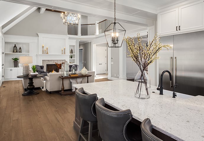 Open concept kitchen and living room renovation with large island, vaulted ceiling, and custom trim