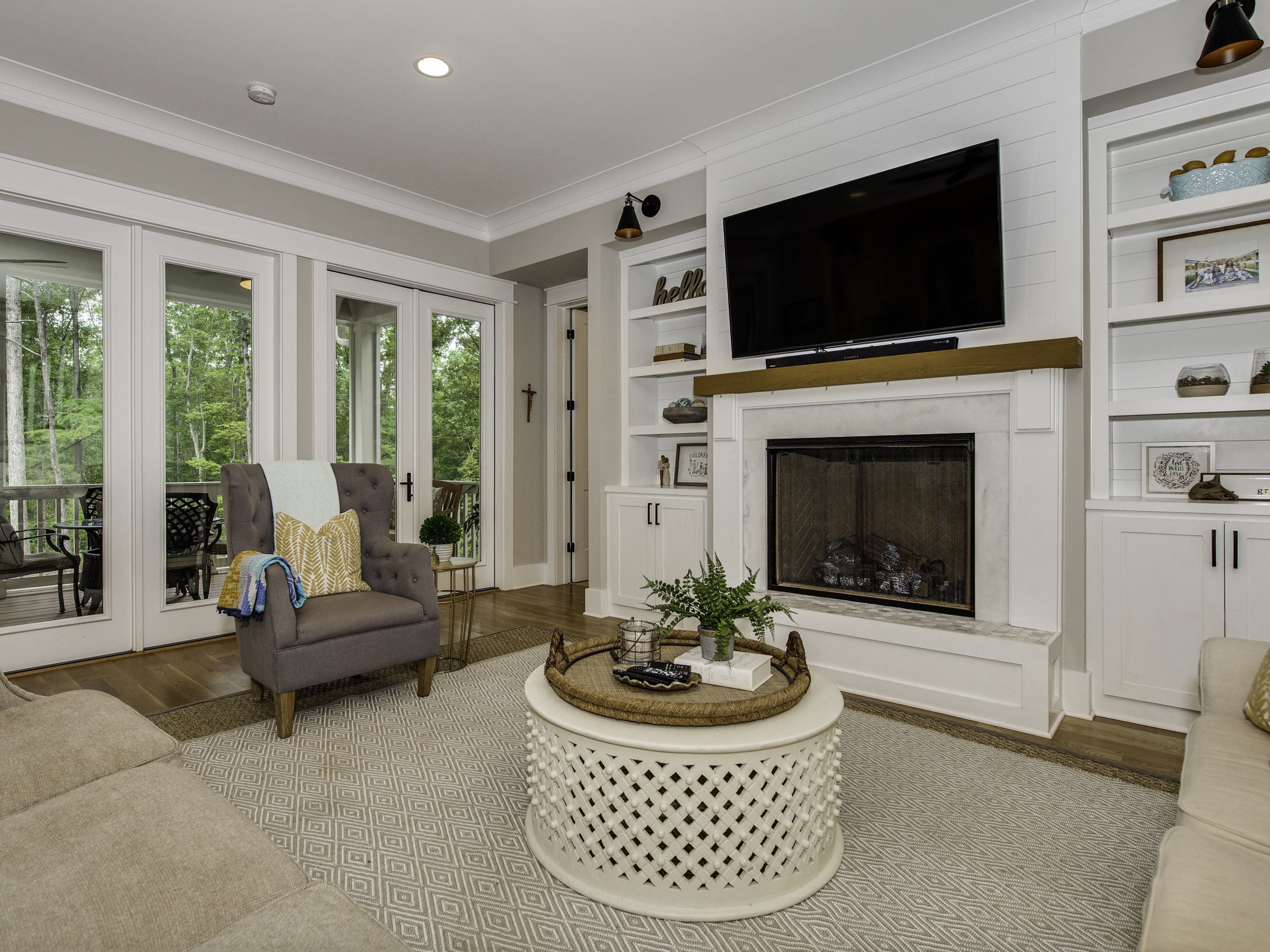Living room renovation with built-in cabinets, fireplace, and French doors to outdoor space