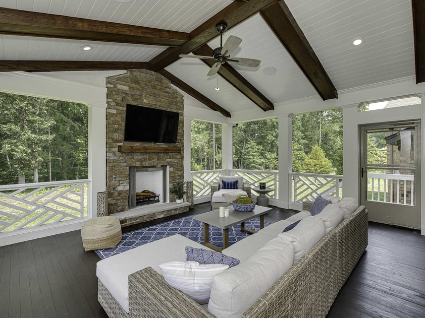 Screened-in porch remodel with stone fireplace, vaulted ceiling beams, and outdoor living space