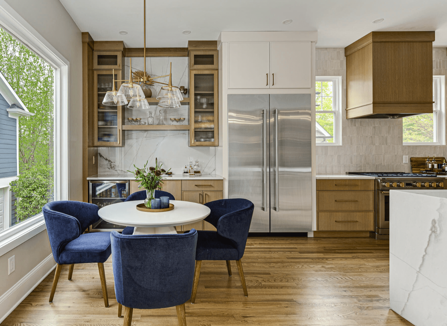 Kitchen renovation with custom cabinetry, dining area, large window, and modern pendant lighting