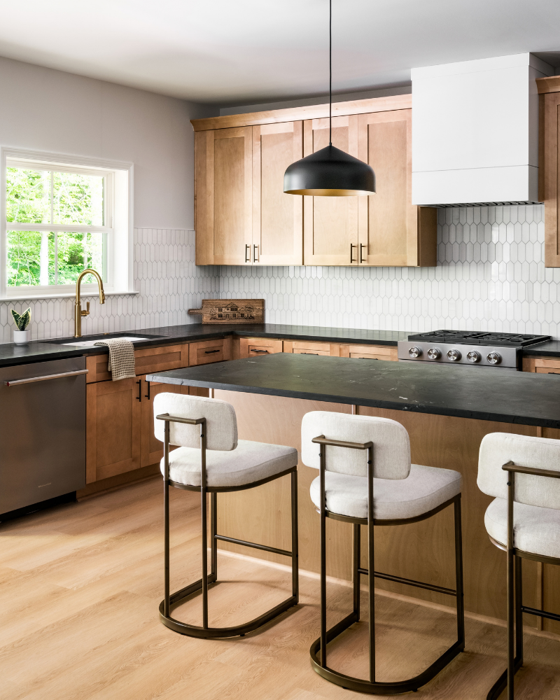 Brass pull-down faucet and undermount sink under a new window, with black quartzite counters and white picket tile backsplash Brass pull-down faucet and undermount sink under a new window, with black quartzite counters and white picket tile backsplash