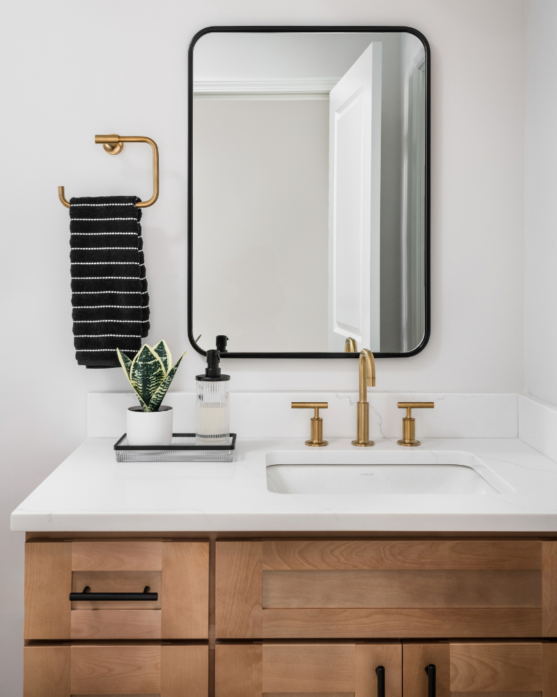 Basement full bath in Indian Land, SC with a white hex tile shower, frameless sliding glass door, brass fixtures, and wood vanity Basement full bath in Indian Land, SC with a white hex tile shower, frameless sliding glass door, brass fixtures, and wood vanity